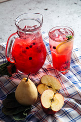 Glass and a jar with fresh fruit red lemonade