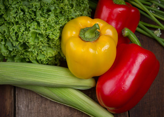 Curly green kale and bell peppers on a rustic wooden table