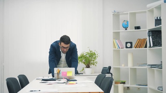 4k slowmotion video confident and handsom executive director decisively leans on a conference table.