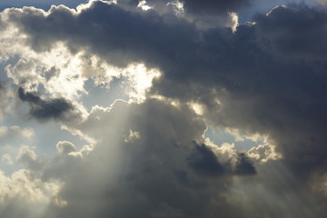 Naklejka na ściany i meble Sunrays piercing through the clouds