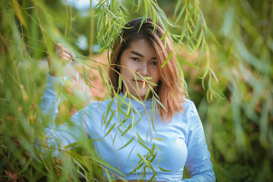 Portrait Asian woman  at Willow tree in the garden in park.