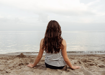 Fototapeta na wymiar young woman sitting on the beach