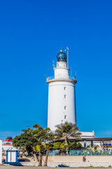 White lighthouse in the port of Malaga, wonderful sunny day with a blue cloudless sky in Spain