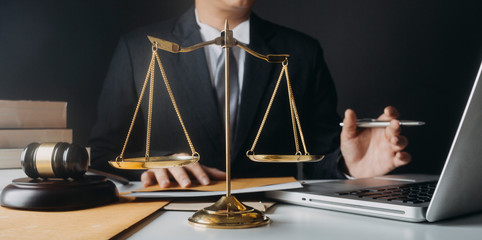 Justice and law concept.Male judge in a courtroom with the gavel, working with, computer and...