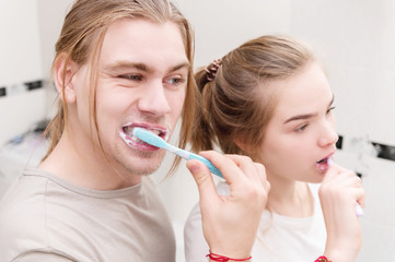A young pair of long-haired mellils brush their teeth in the bathroom in the morning. A healthy smile and dental and oral care