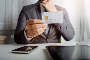 businesswoman hand using smart phone, tablet payments and holding credit card online shopping, omni channel, digital tablet docking keyboard computer at office in sun light