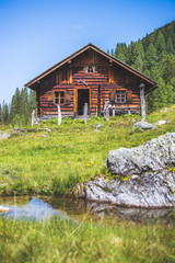 Idyllic mountain landscape in the alps: Mountain chalet, meadows and blue sky