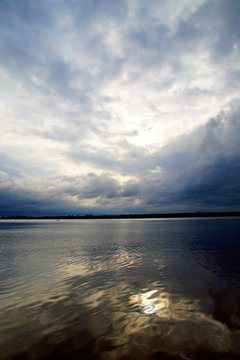 Cloudy day at Lake Lepel. Dark rain clouds and reflection on the water surface. Horizon and space.