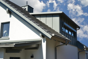 Gaube mit Stehfalz-Metall-Verkleidung des Dachgeschosses am Ziegeldach eines modernen...
