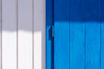 White and blue wooden background with a hinge in the middle