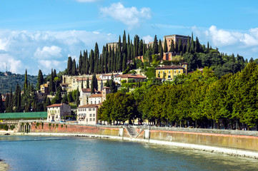 Panoramic view of Castel San Pietro (St. Peter Castle) on hill with cypress trees over the Adige...