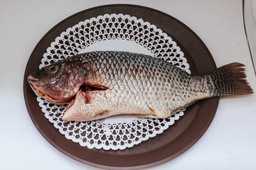 Top view of an uncooked fish on a plate