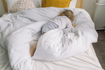 Little boy with curly blonde hair sleeping in bed. Sleep time concept.