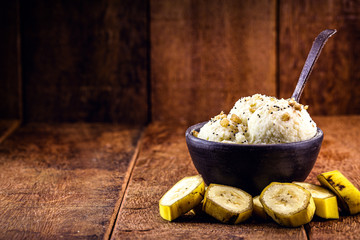 Vegan ice cream made with frozen bananas, with no added dairy, served in a handmade clay bowl, on a...