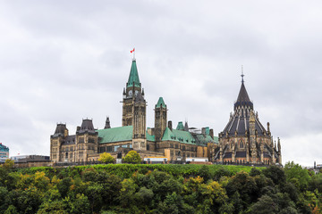 Fototapeta na wymiar Parliament Hill, Ottawa, Rideau canal in Autumn. Cloudy sky