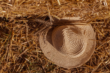 straw hat with ears of wheat on a background of wheat straw