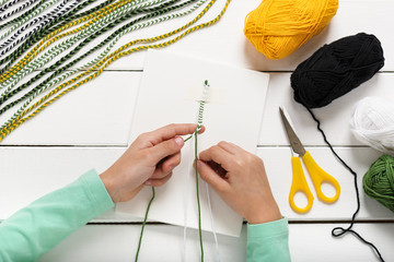 Child makes braids of wool. Making home decorations. Easy fun kids crafts concept. Step 1. 