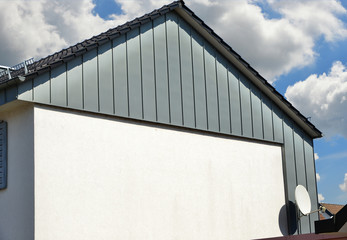 Obraz premium Stehfalz-Metall-Fassadenverkleidung des Dachgeschosses an einem modernen Einfamilienhaus