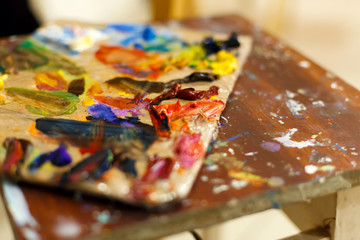 Close-up of an easel with paints, the artist paints a brush. Painting a picture.