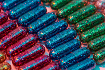 Creative concept with many colorful glitter pills lying in rows diagonally. Minimal style, art concept