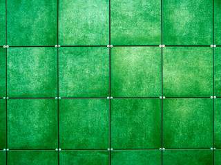 Wall  made of green square tiles