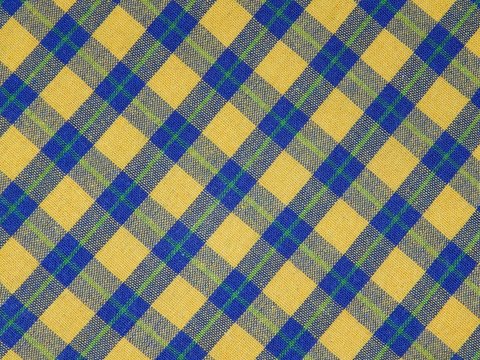 Blue and yellow diagonal checkered stripes plaid Scottish fabric texture photo, textured textile tablecloth pattern, background, banner, frame,wallpaper design.