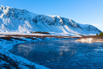 Iceland's breathtaking winter landscapes. River with pieces of ice on the background of mountains