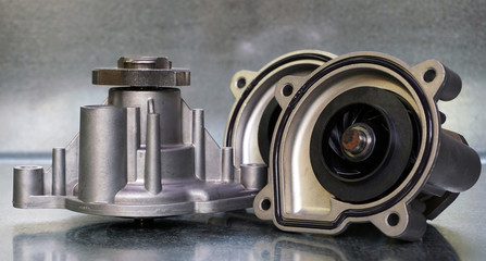 Coolant pump of a modern car on a steel background. Shown from the outside and from the impeller...