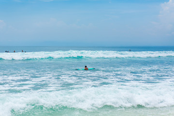 The guy is swimming on the surf board on the ocean. Healthy active lifestyle in summer vocation.