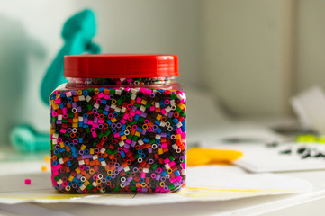 Selective focus shot of different colors of pulsa beads in a jar