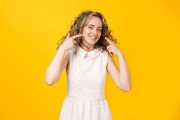 Portrait of a young smiling woman showing her smile with her fingers. Female portrait.