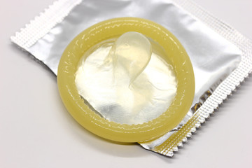 An opened condom package on a white background