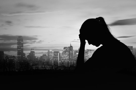 Sad, depressed woman  silhouette in the city 
