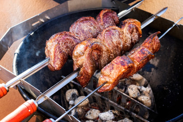 Barbecue dry aged wagyu picanha skewer preparing with salt on an open fire kettle grill