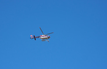 Fototapeta na wymiar Austrian federal police helicopter flying, blue sky in the background