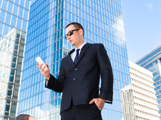 Businessman in the city using smartphone. 