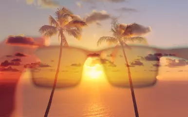 Fototapeten Tropical getaway. Beautiful sunset and palm trees through sunglasses  © kieferpix