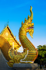 Fototapeta na wymiar Golden serpent king or king of naga statue with Beautiful Sky, Udon Thani Province, Thailand.