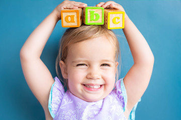 Happy preschool child learning abc with toy blocks. Back to school.