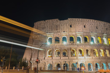 Coliseu iluminado em foto noturna de longa exposição com os rastro de luzes dos veículos