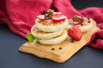 A healthy breakfast of pancakes, strawberries, chocolate, and honey
