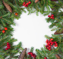 Creative layout of the branches of the Christmas tree with pine cones and paper card note. Concept of the new year of nature. Flatley
