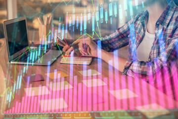 Fototapeta na wymiar Double exposure of businesswoman hands typing on computer and forex graph hologram drawing. Financial analysis concept.