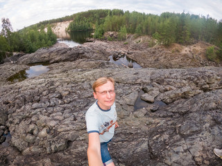 man stands on stones geological object the most ancient volcano crater in Karelia Russia