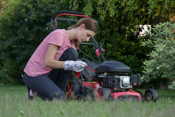 Woman checking lawn mower oil