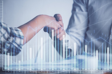 Double exposure of forex graph hologram and handshake of two men. Stock market concept.