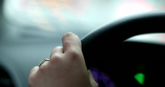 Hand holding steering wheel driving close-up