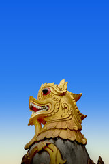 Fototapeta na wymiar Beautiful golden lion sculpture with blue sky Located along the cliff on the mountain in Phra That Doi Kong Mu Temple at northern Thailand