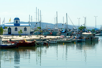 Fishing boats and  the chapel of Saint Nikolaos  in the port of Nea Artaki, Euboea / Greece.  Sunny...