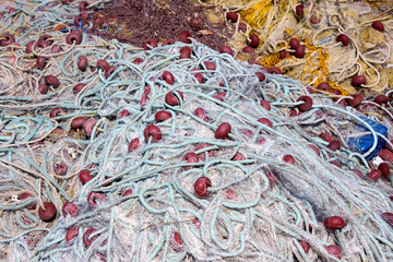 pile of colourful fishing nets with floats and ropes. Sunny day